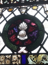 Detail of stained glass window showing regimental motif or badge.