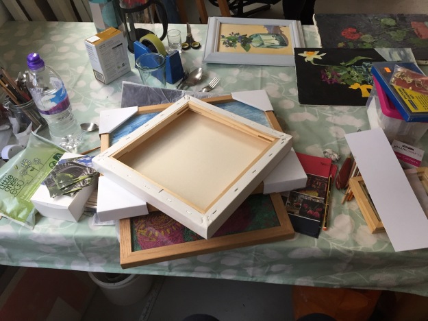 My table in the studio as I put work into frames and added fixings to paintings on canvas.