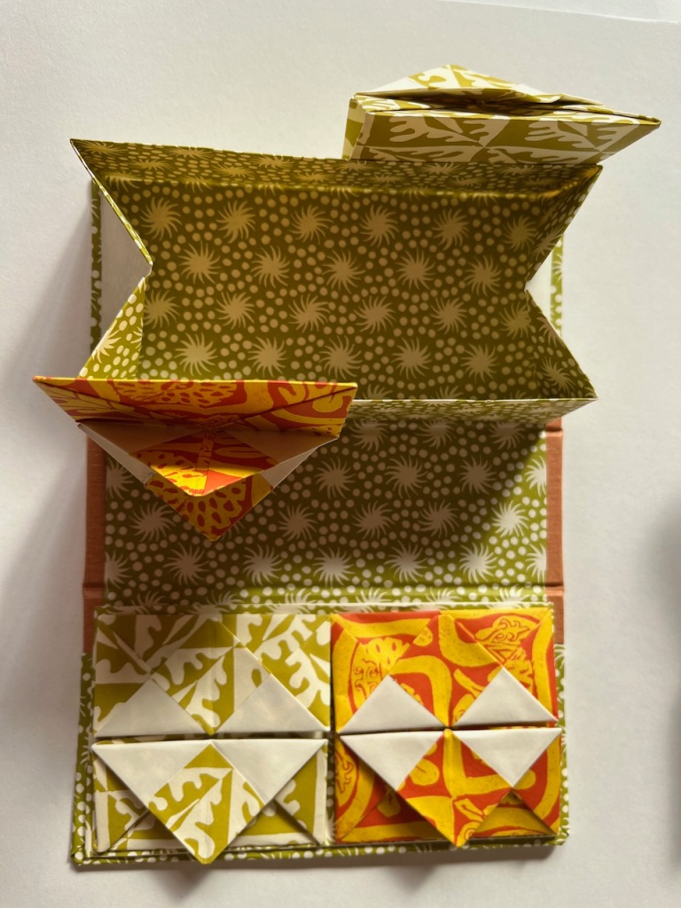 A Chinese thread book in green, and red and yellow, decorative papers published by Cambridge Imprint.